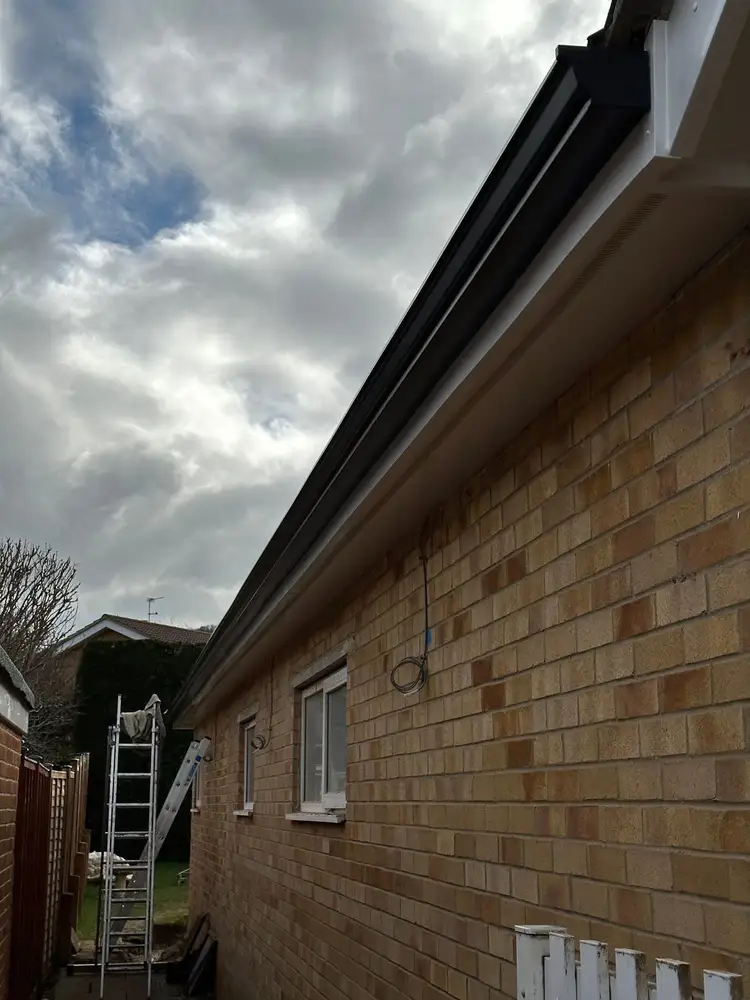 Black guttering, fascia and soffit fitted to a brick house