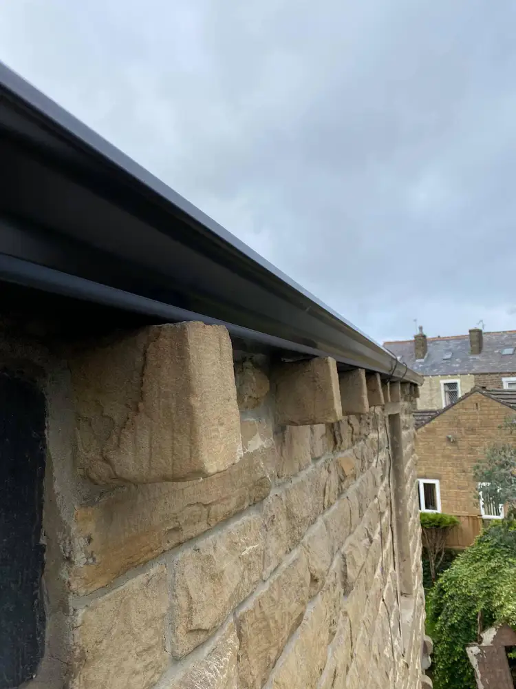 Black guttering installed on a Yorkshire stone property